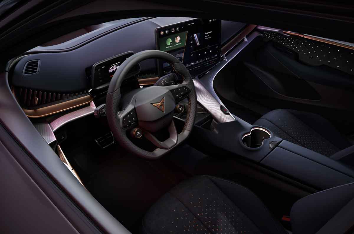 Interior del CUPRA Tavascan con salpicadero, pantalla central, volante con logo CUPRA y consola central iluminada