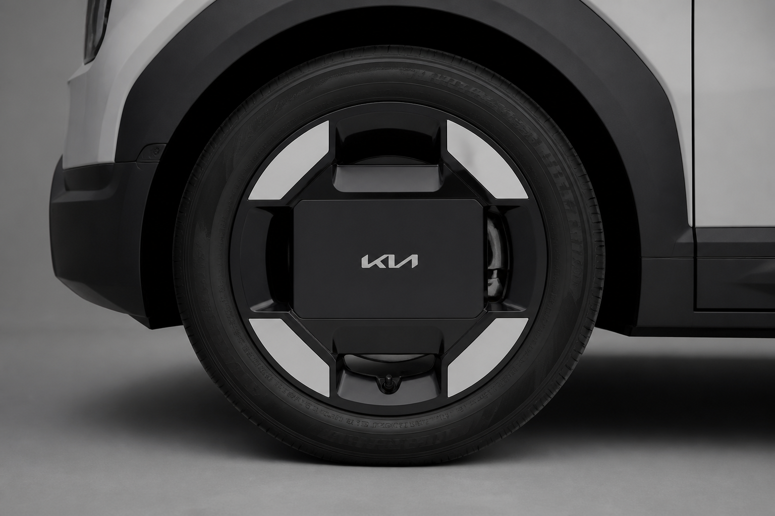 Primer plano de la llanta de aleación de 16 pulgadas con el logo de Kia sobre fondo de estudio neutro.