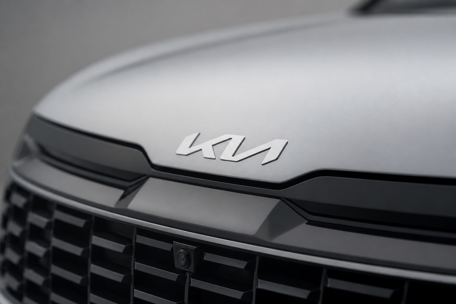 Primer plano del emblema Kia en el frontal del vehículo