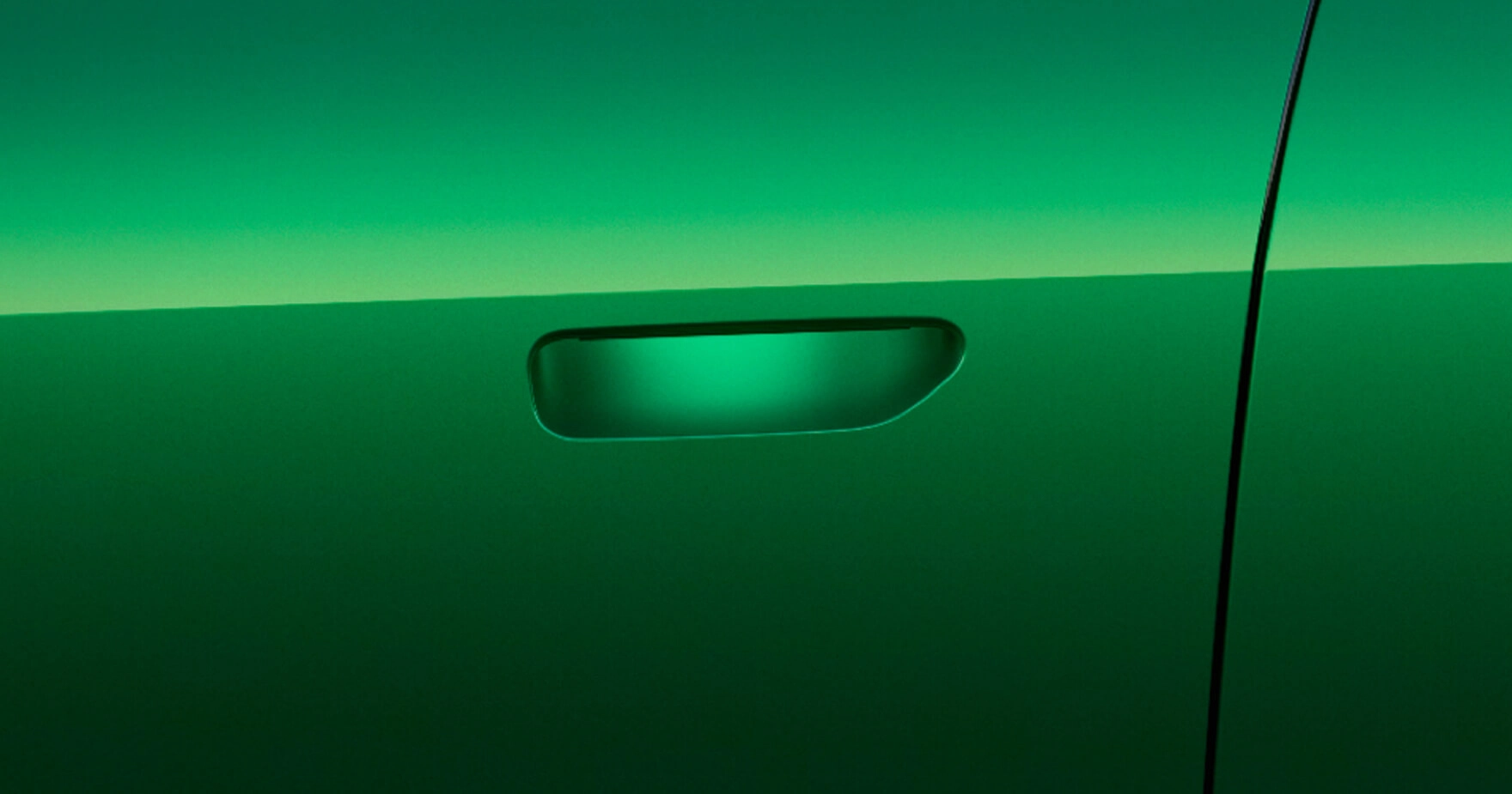 Manija enrasada del YU7 verde realzada por iluminación ambiental verde sobre la carrocería