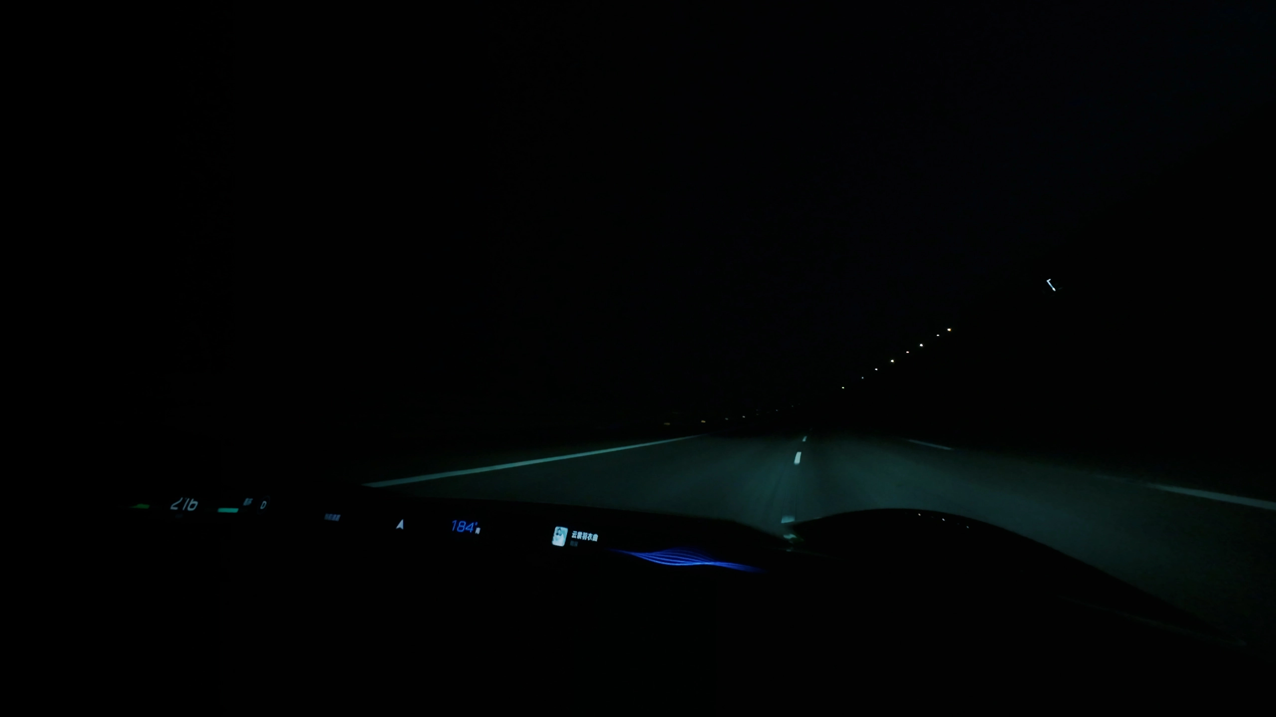 Vista nocturna desde el puesto de conducción con la carretera iluminada y elementos del cuadro digital