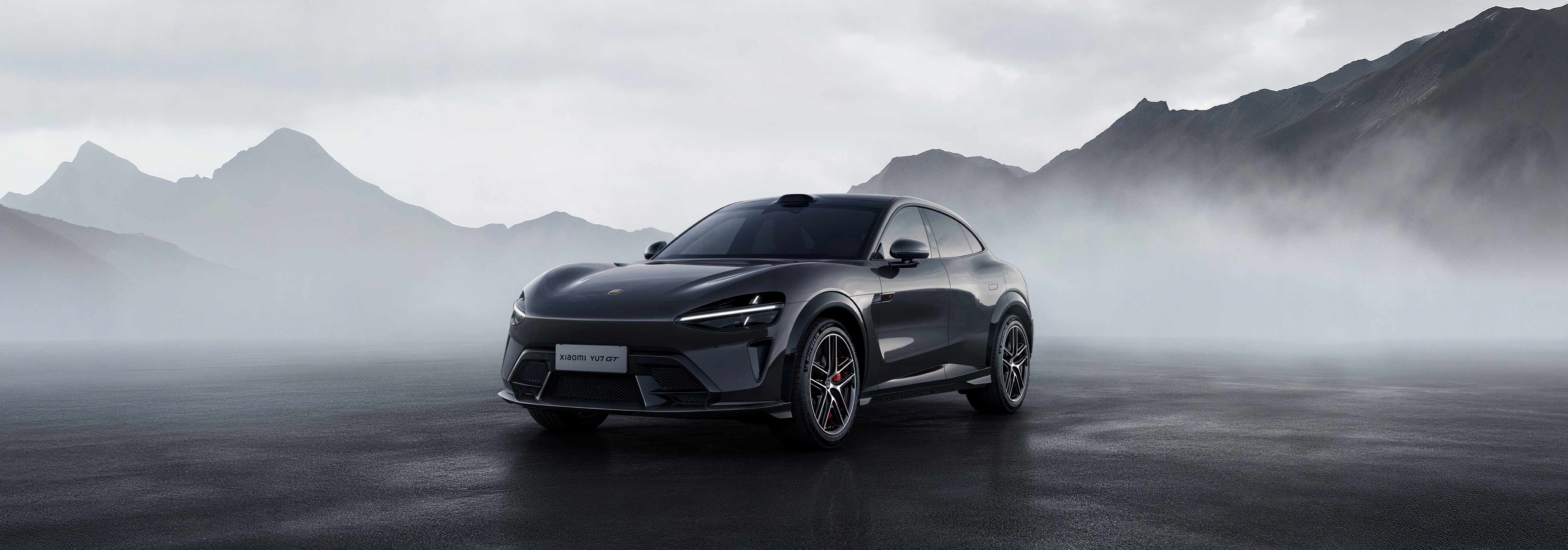 YU7 GT en tono gris oscuro sobre un paisaje montañoso brumoso, en tres cuartos frontal
