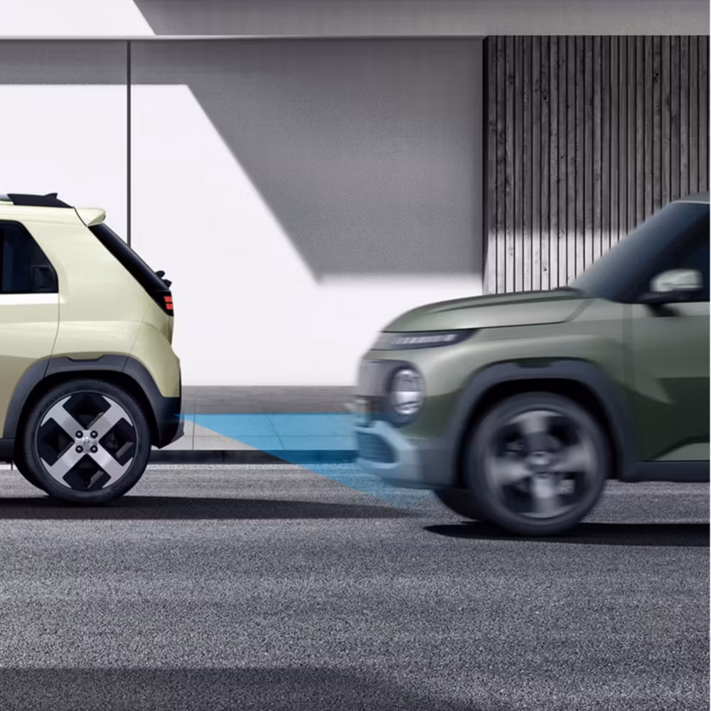 Ilustración de seguridad con dos Hyundai Inster y un haz azul que representa la detección de colisión frontal