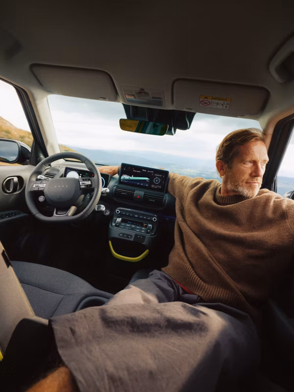 Interior del Hyundai Inster con el conductor al volante, instrumentación digital y pantalla central de infoentretenimiento