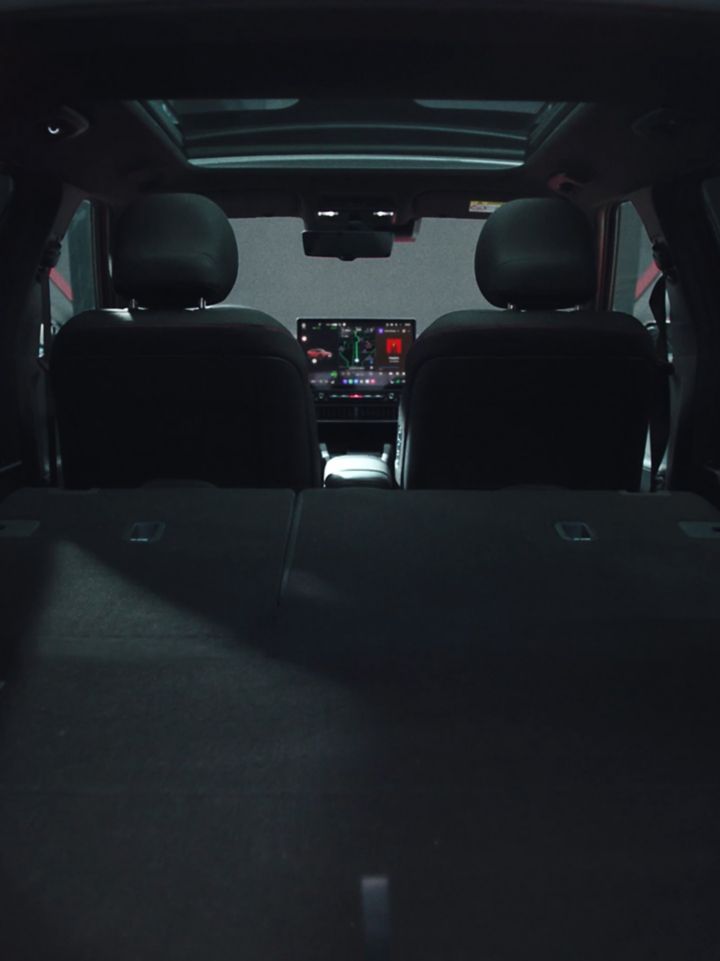 Zona de carga con los asientos traseros abatidos, vista hacia los asientos delanteros y el techo panorámico