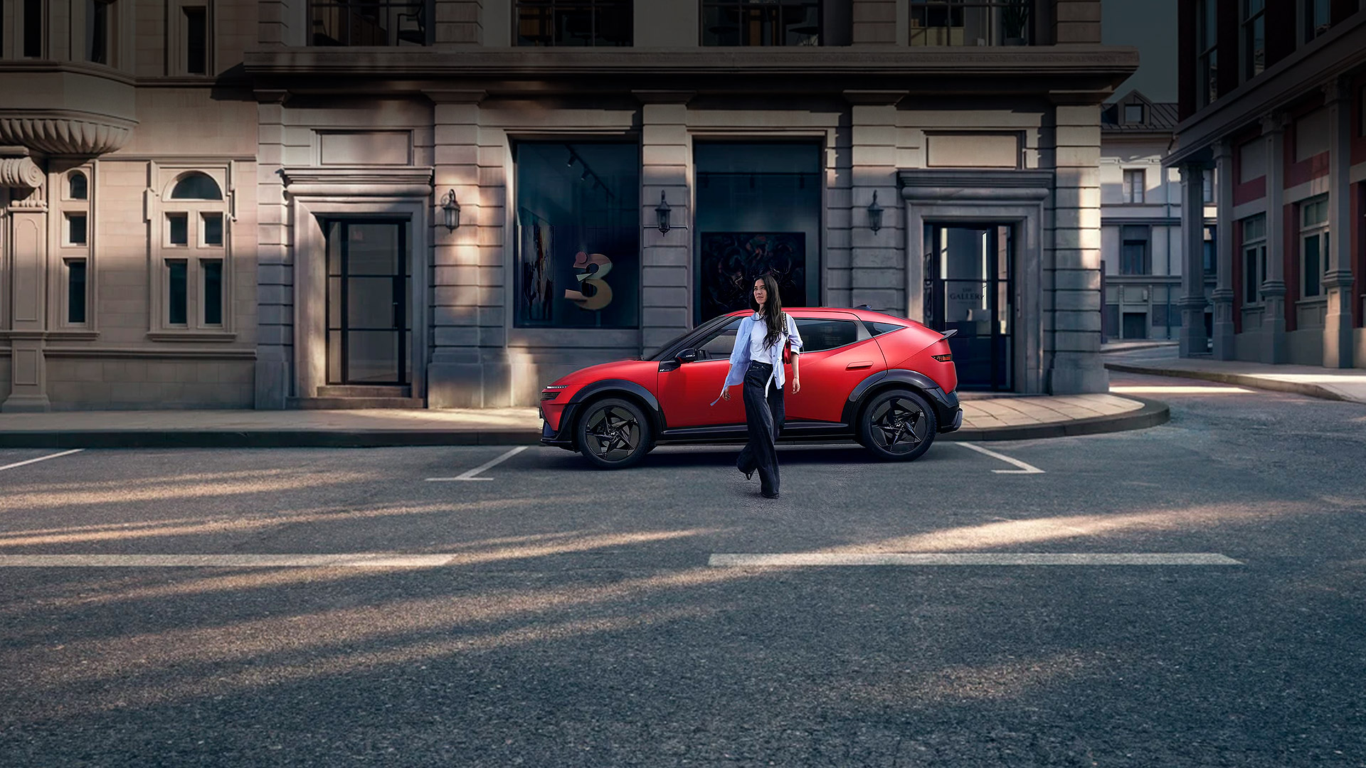 Vista trasera del IONIQ 3 rojo con techo negro y luces traseras LED encendidas sobre fondo blanco