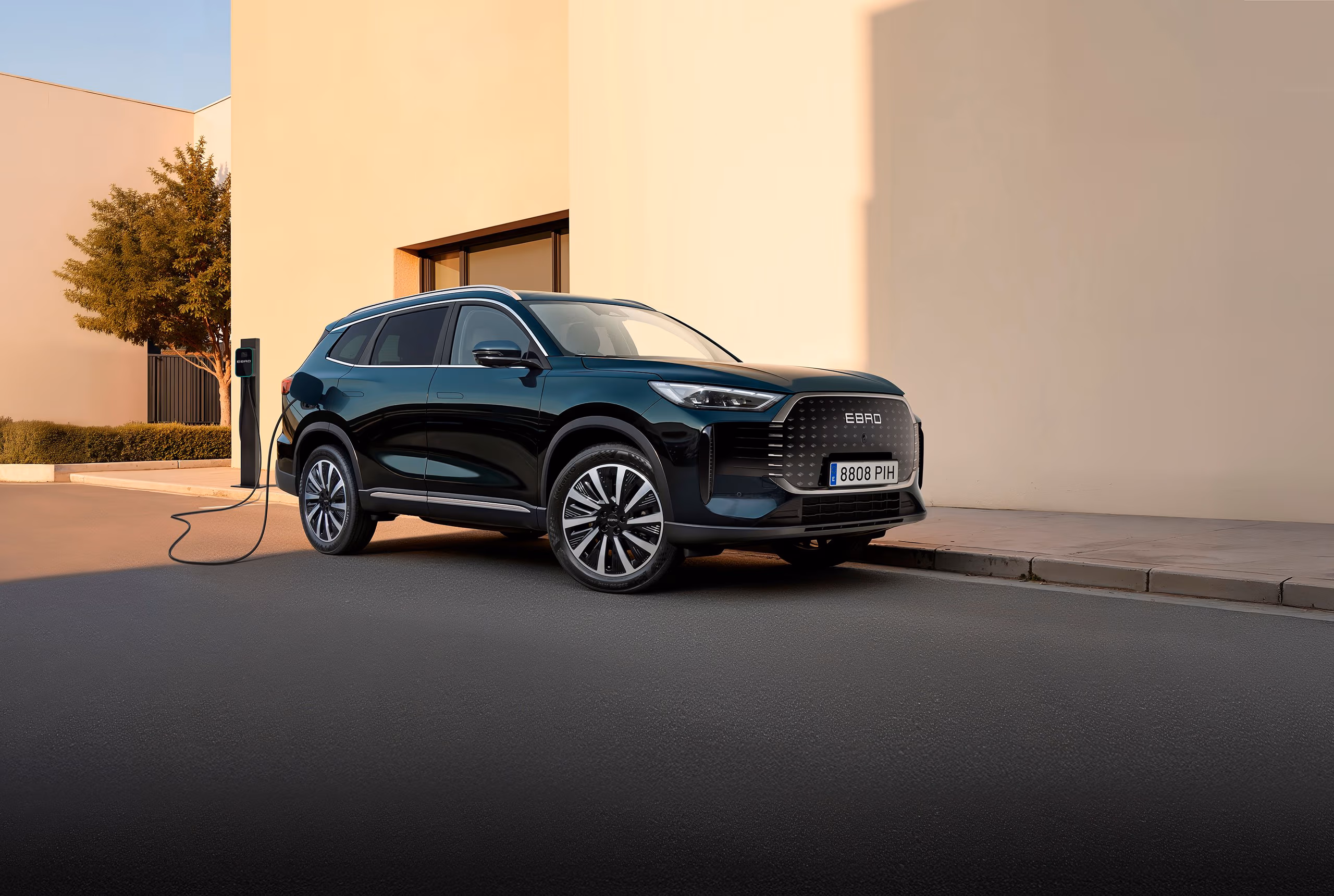 Ebro S900 verde oscuro enchufado a un punto de carga urbano de día