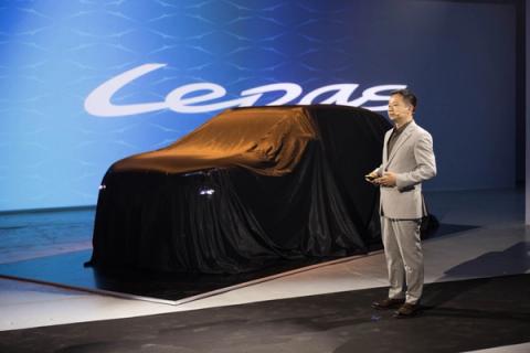 Presentación en escenario de un coche cubierto bajo el logotipo Lepas