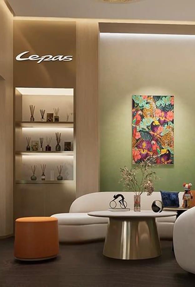Zona lounge de un concesionario con sofá, mesa y estanterías decorativas