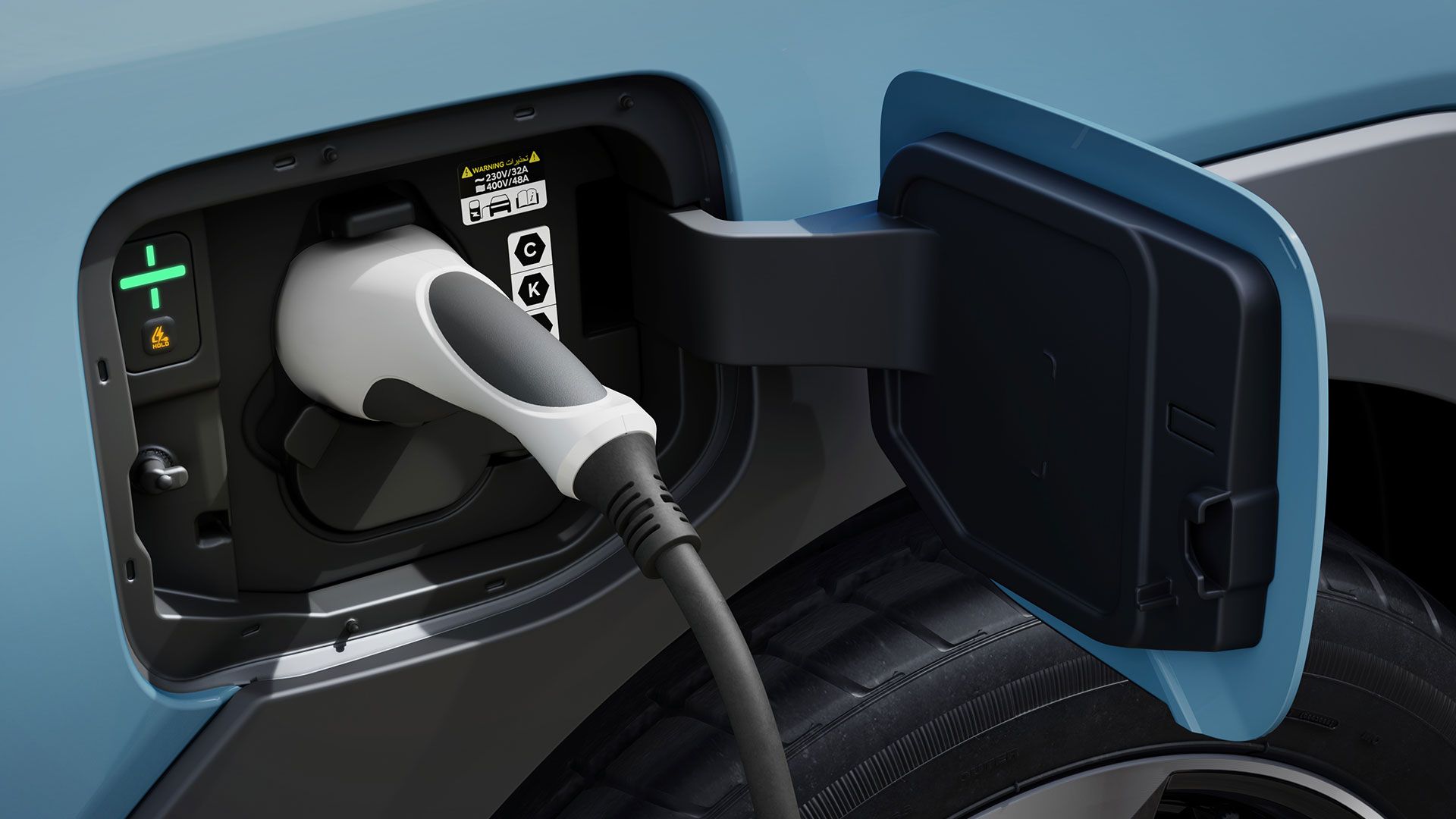 Conector de carga insertado en el puerto del Kia EV2 con la carrocería azul visible