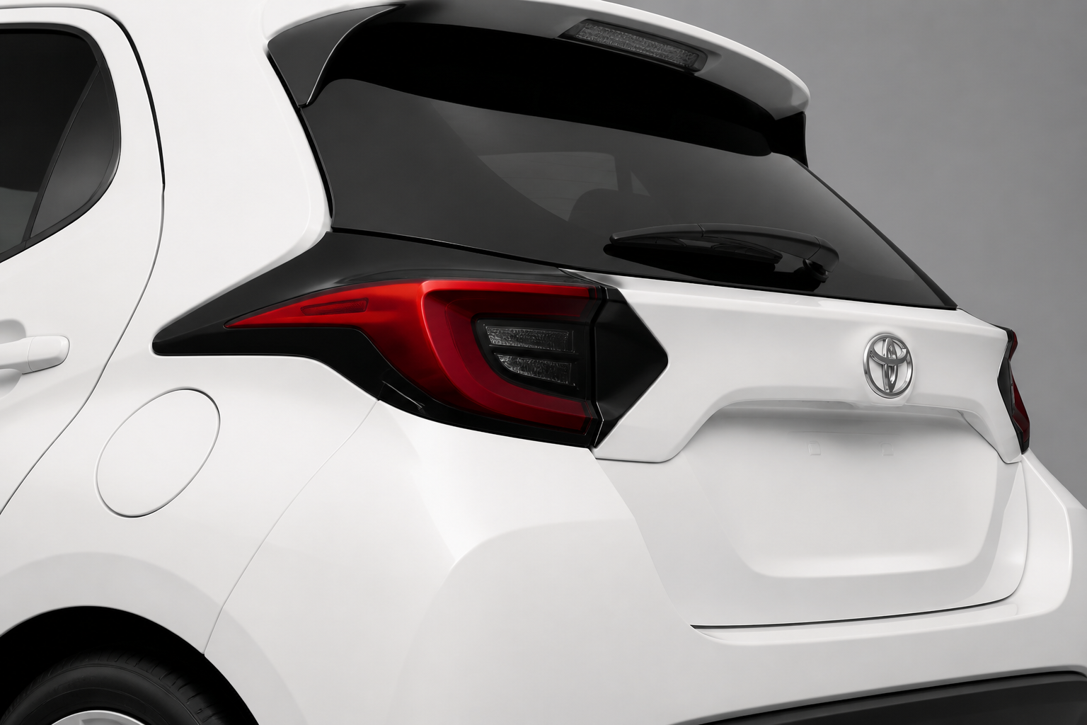 Detalle de la zaga del Toyota Yaris blanco con el piloto trasero y el portón