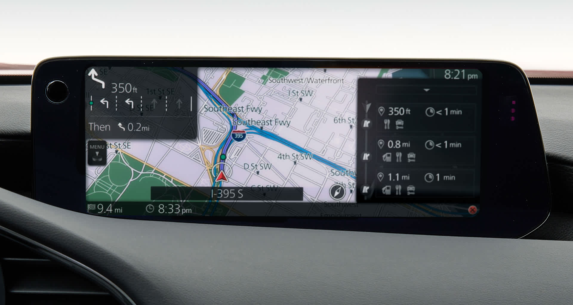Pantalla de infoentretenimiento mostrando un mapa de navegación con indicaciones giro a giro, junto al mando rotatorio