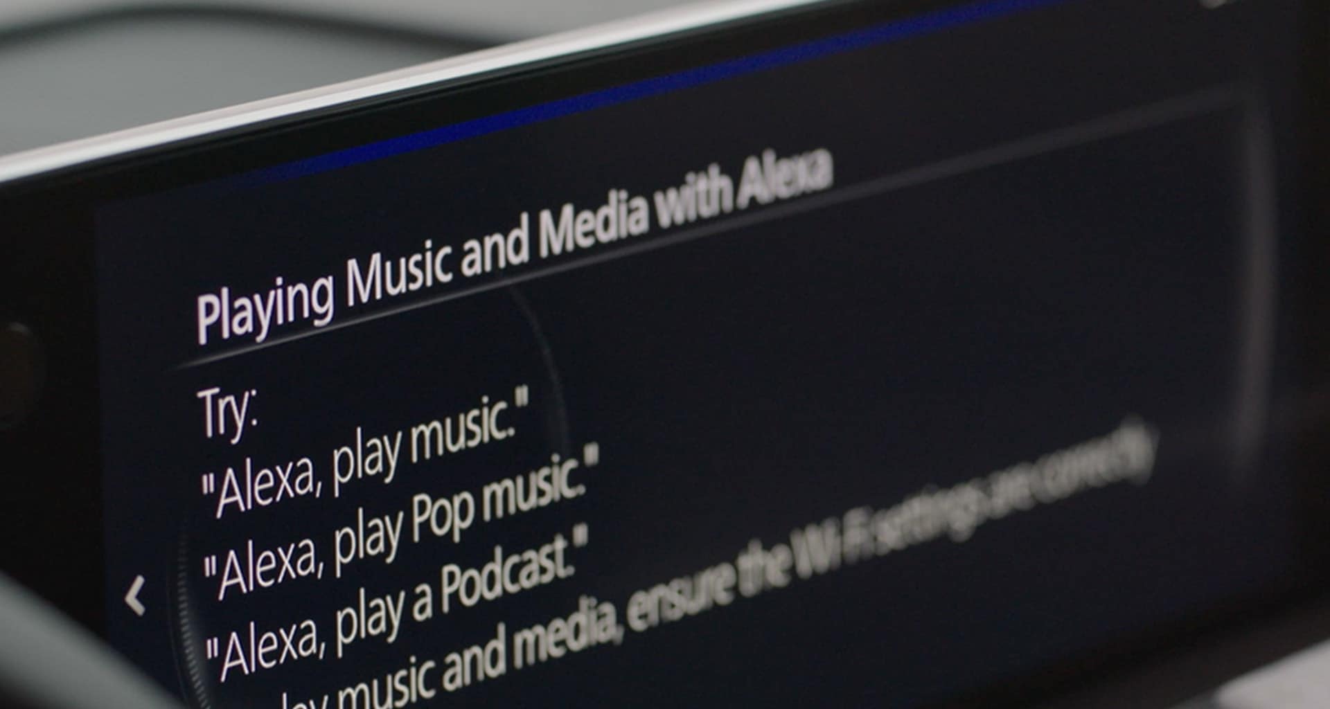Pantalla del sistema mostrando el menú de comandos de voz de Alexa con ejemplos de uso