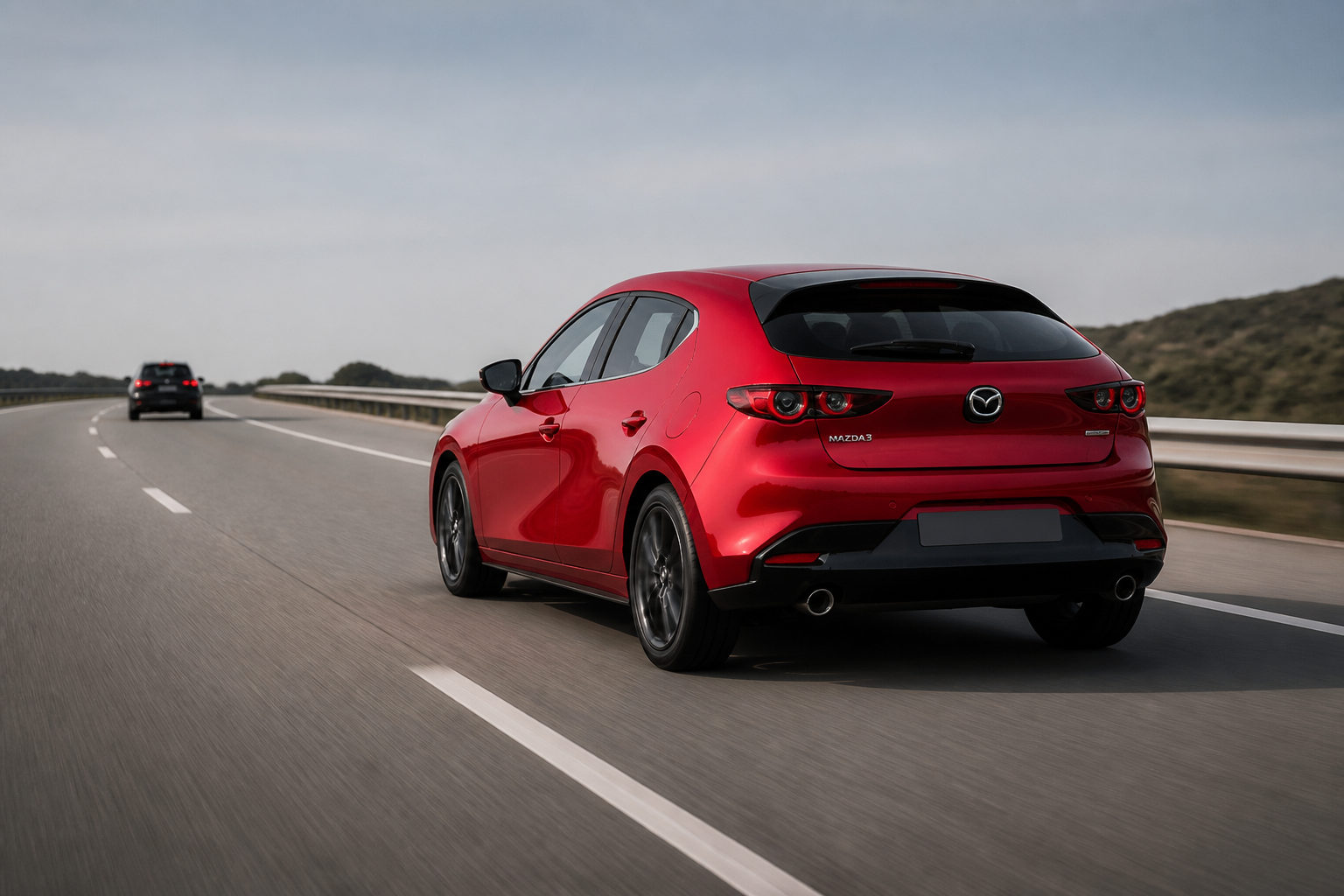 Tres cuartos trasero del Mazda3 rojo circulando por autopista manteniendo distancia con un vehículo lejano