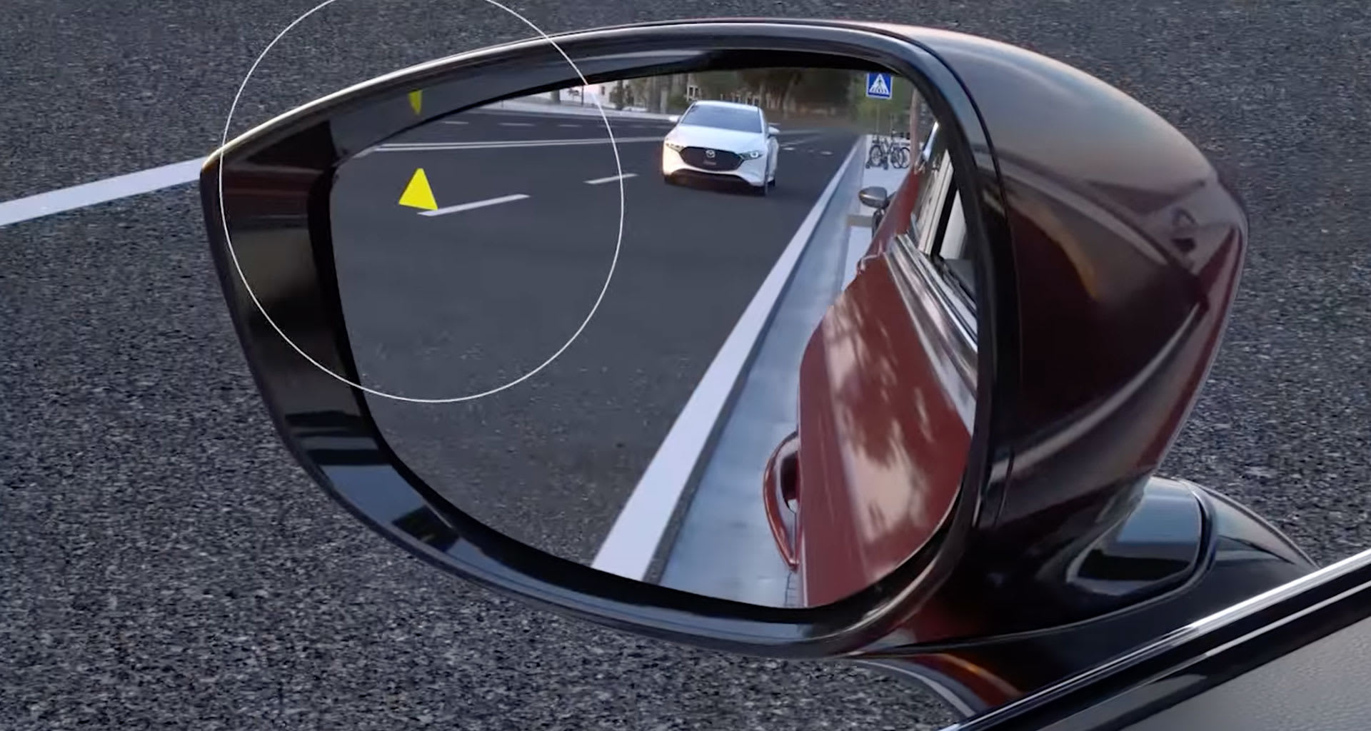 Retrovisor exterior con el aviso luminoso del asistente de ángulo muerto activado y un Mazda3 blanco reflejado