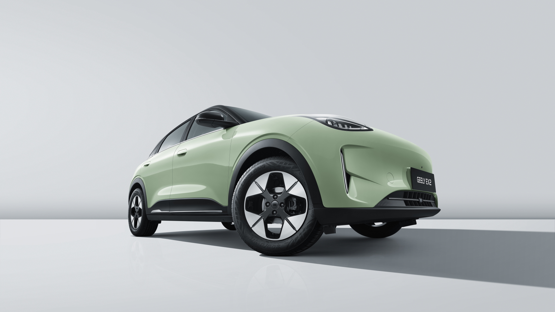 Geely E2 en Verde Halo con techo negro bitono y llantas de aleación multirradio bicolor, vista tres cuartos delantera