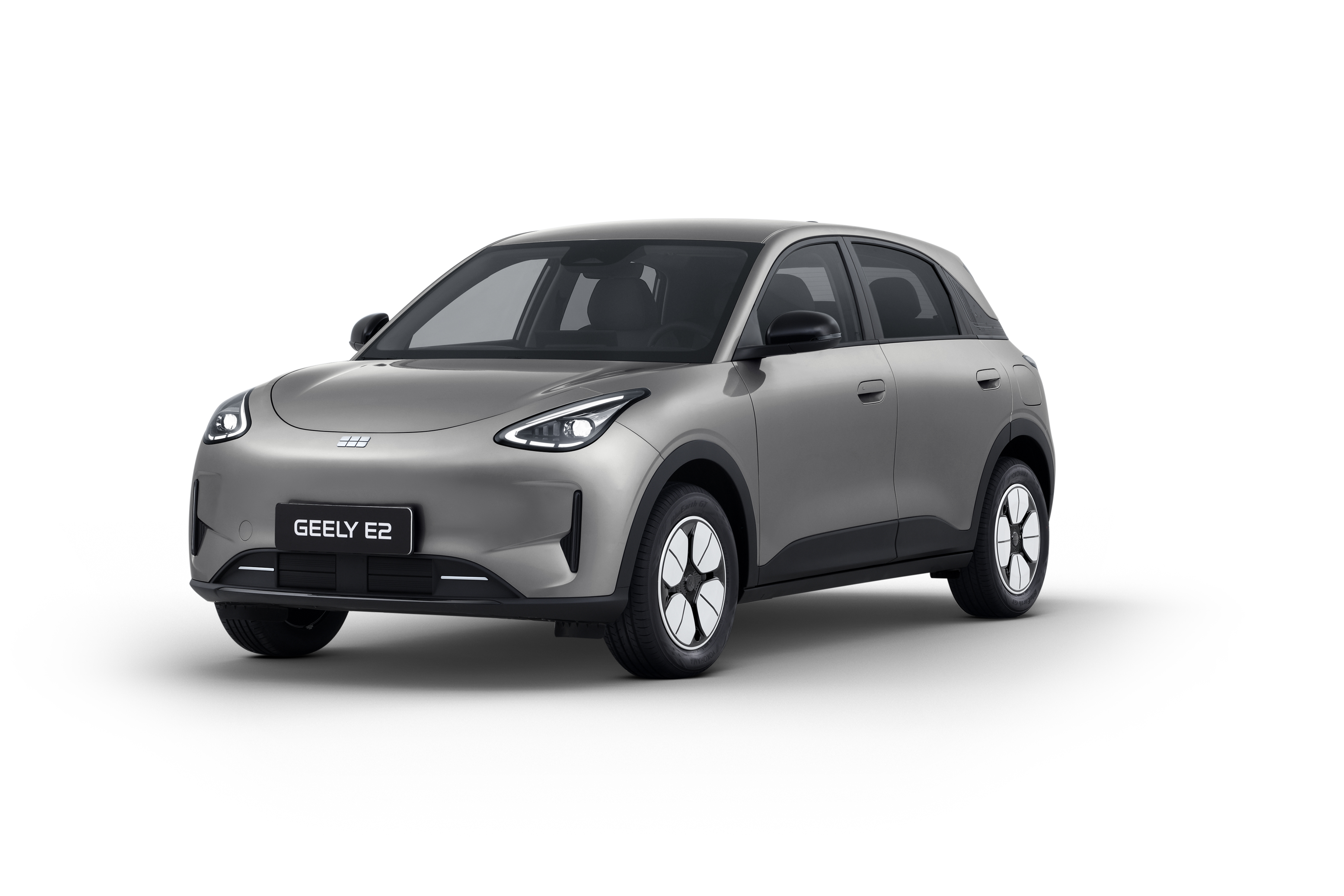 Geely E2 gris plata en tres cuartos delantero con llantas aerodinámicas bicolor sobre fondo blanco
