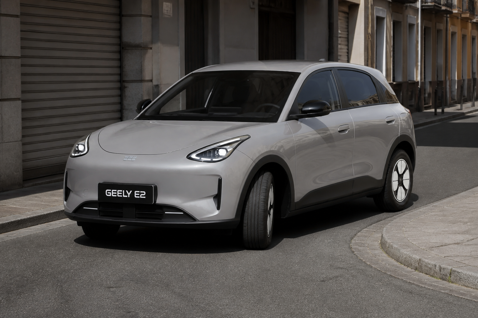 Geely E2 gris maniobrando en una calle urbana estrecha a plena luz del día