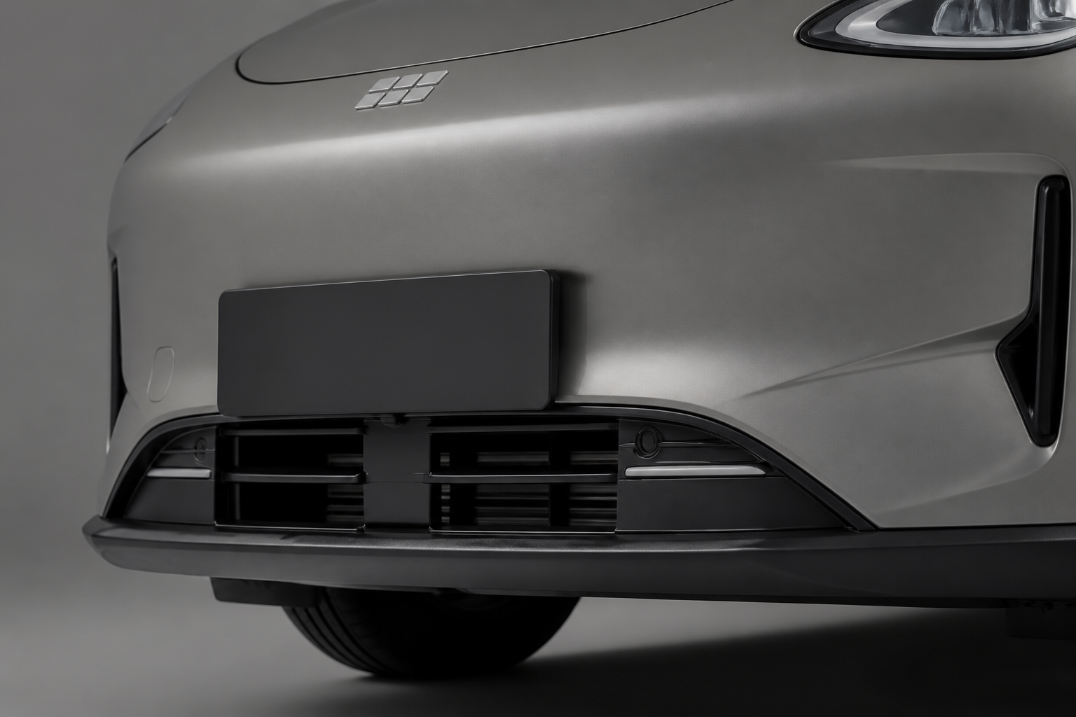 Detalle de la parrilla frontal activa del Geely E2 gris