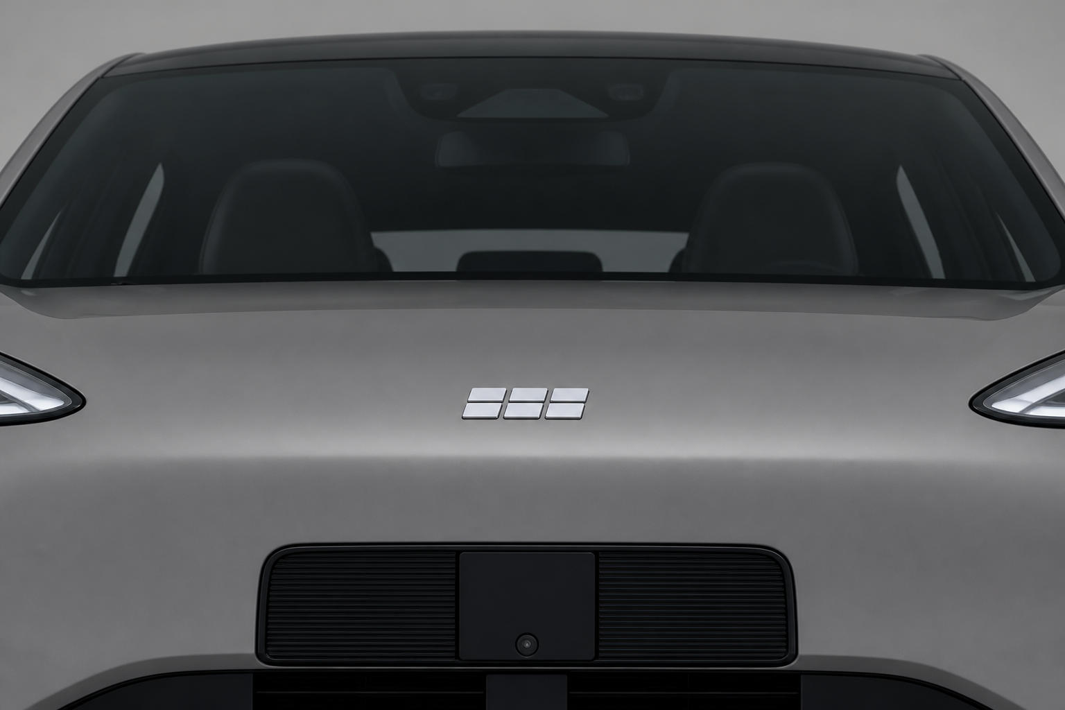 Primer plano del frontal del Geely E2 gris con el sensor de percepción integrado tras la parrilla