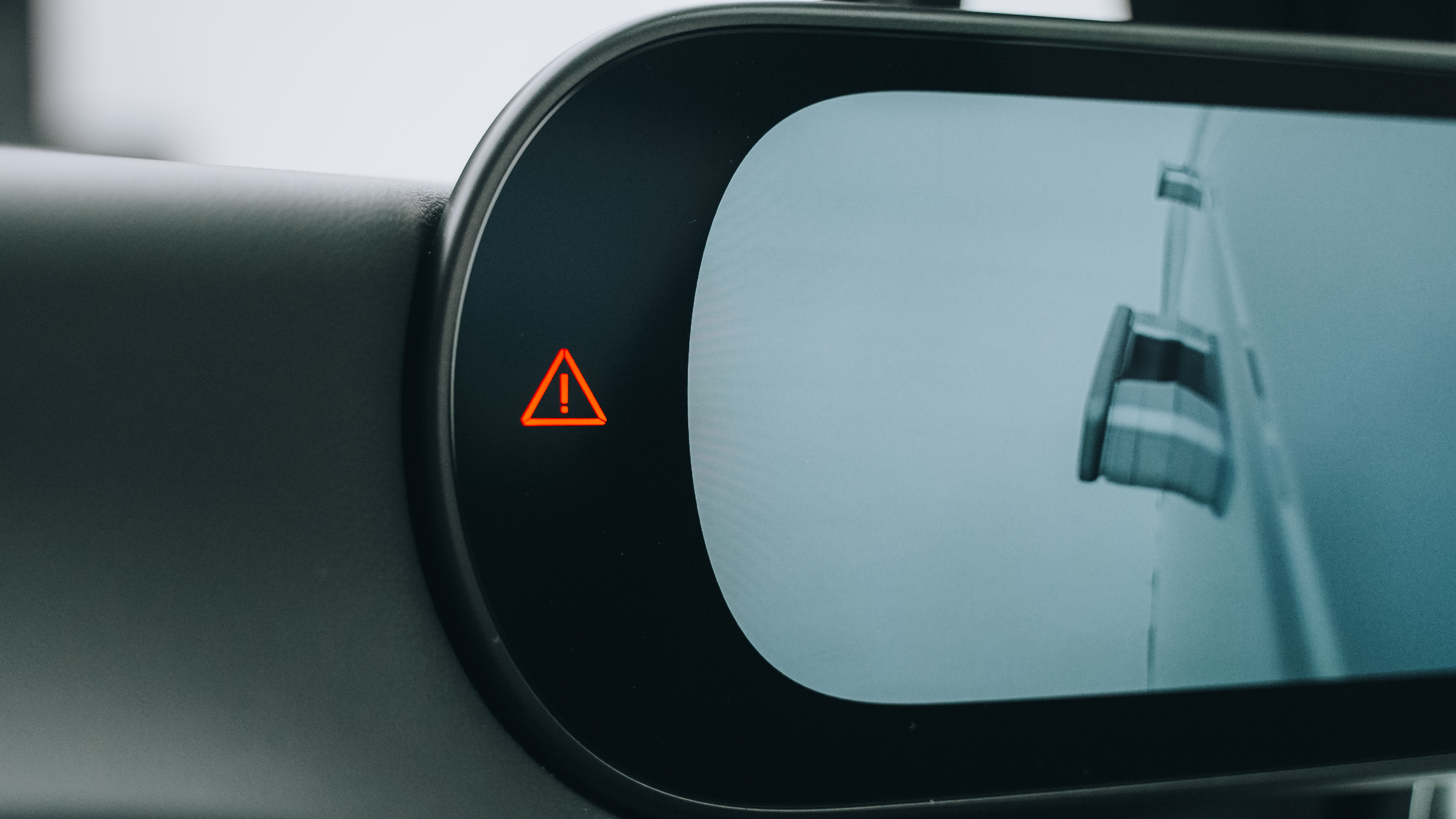 Pantalla de retrovisor digital con el icono de advertencia triangular rojo encendido