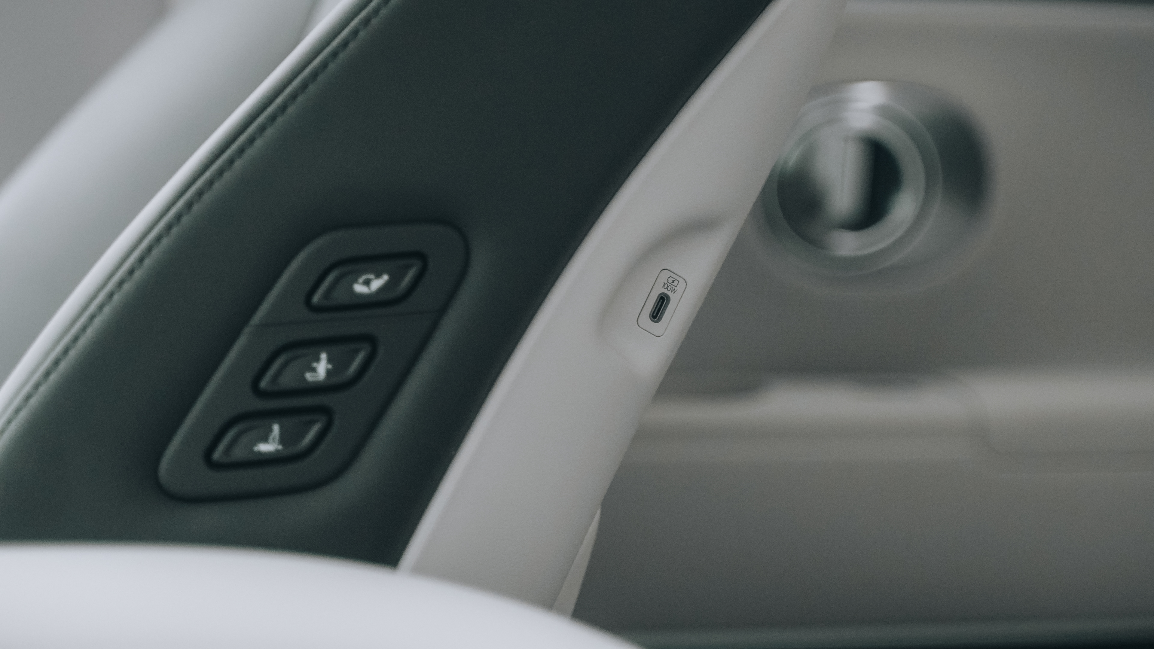 Puerto USB-C junto a los mandos de ajuste de asiento en el lateral del asiento