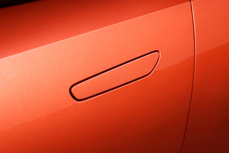Detalle de la maneta de puerta enrasada en carrocería naranja metalizado