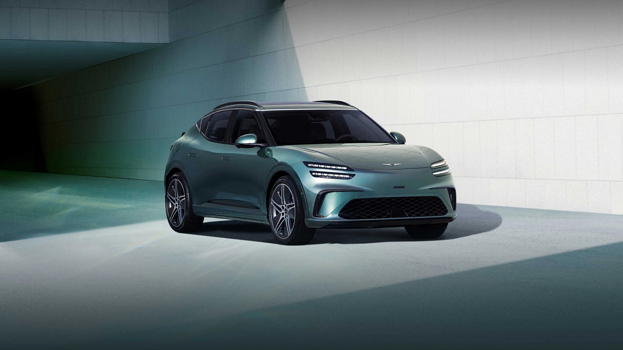 Genesis GV60 de color verde turquesa oscuro con llantas multirradio en un entorno de garaje moderno