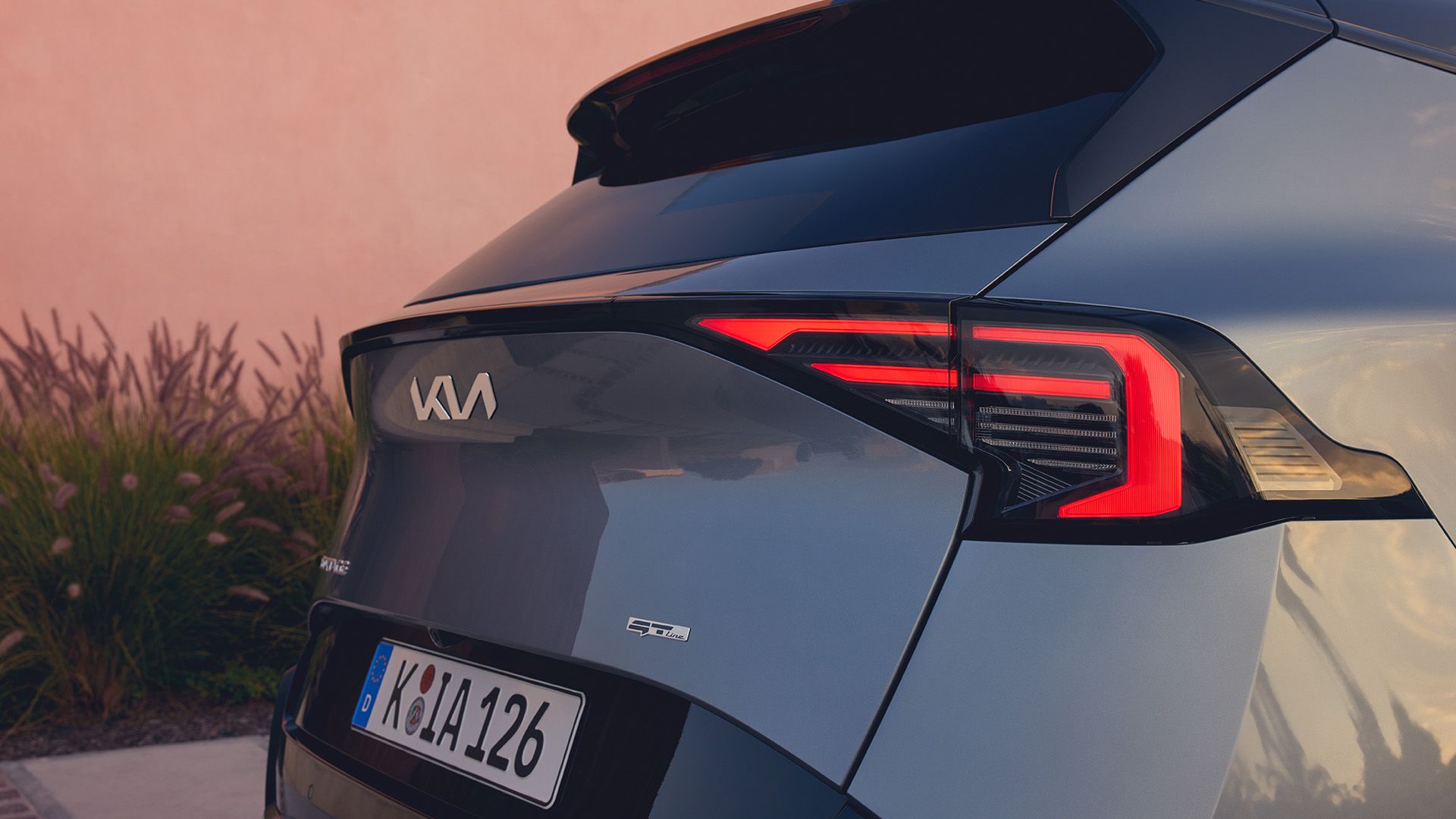Zaga del Sportage GT-Line en gris oscuro con las luces traseras encendidas
