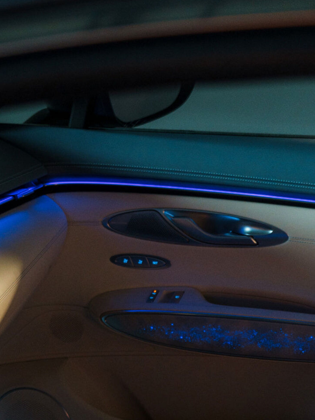 Interior del Electrified GV70 con asientos delanteros y traseros blancos acolchados y detalles en azul pálido en los paneles de las puertas.
