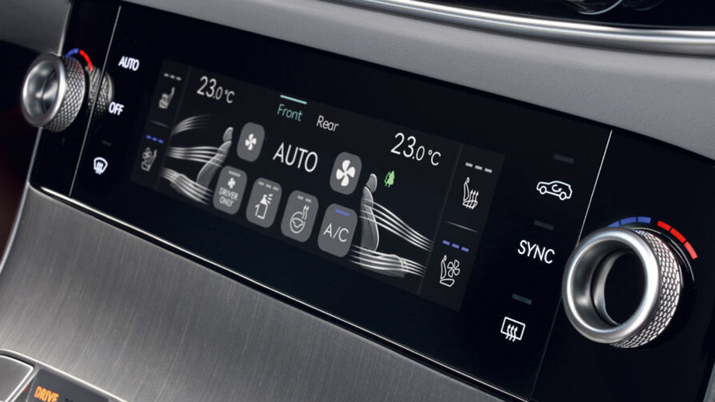 Panel del climatizador con diales giratorios, pantalla digital de temperatura y controles táctiles sobre aluminio cepillado.