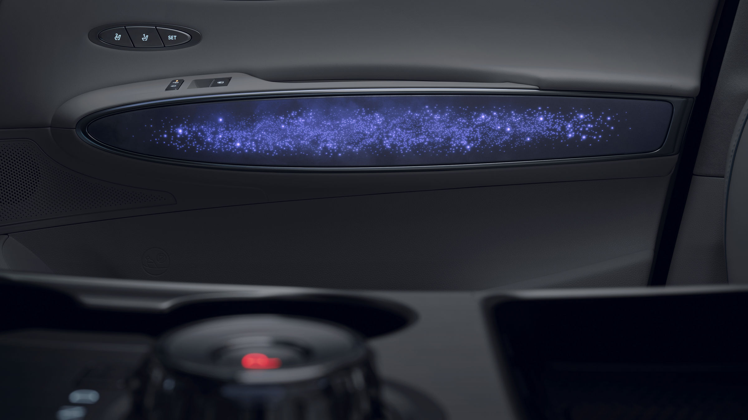 Panel de puerta del Electrified GV70 con iluminación ambiental tipo cielo estrellado en tonos morados y azules.