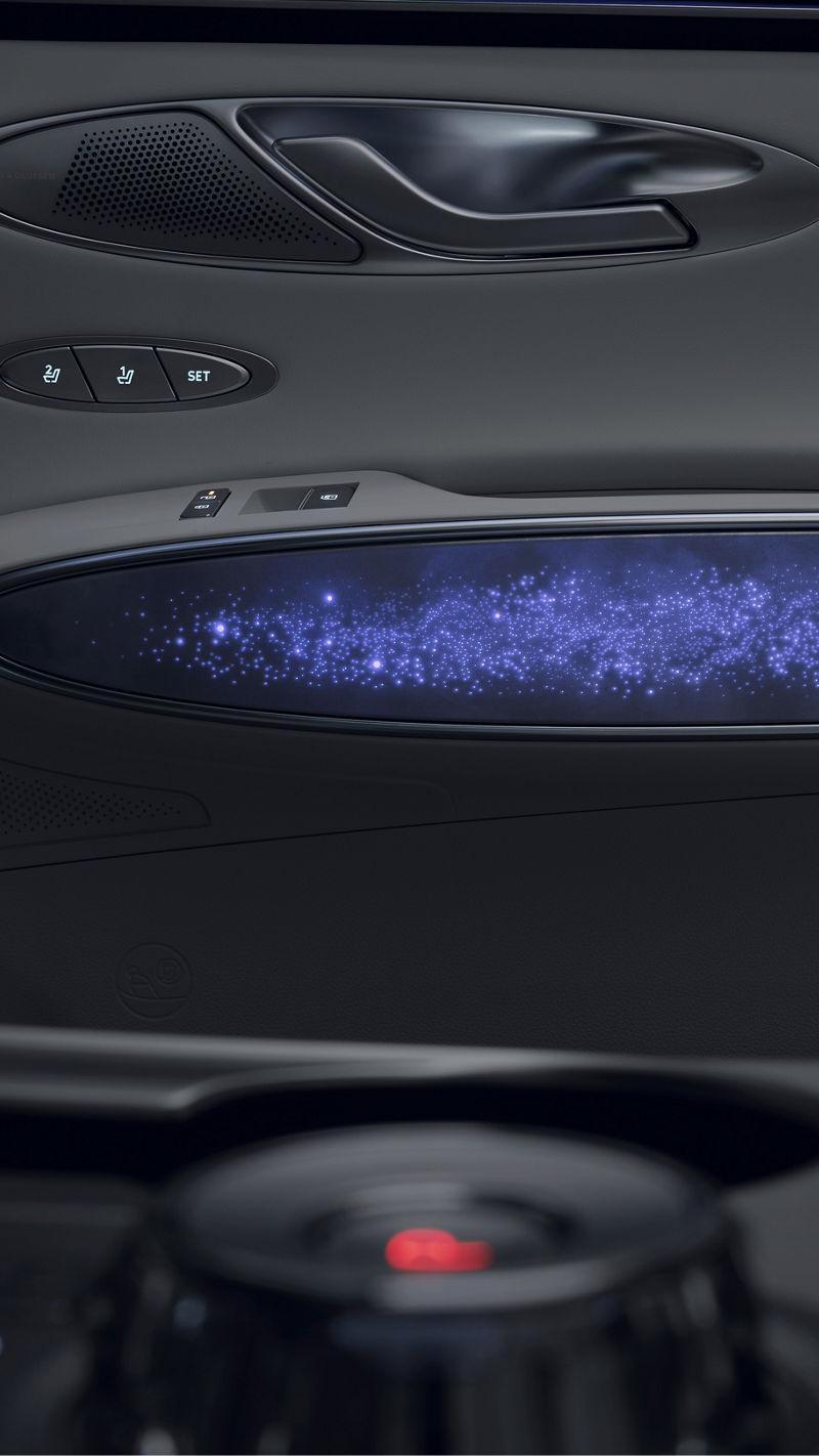 Panel de puerta con altavoz Bang & Olufsen y tira de iluminación ambiental de efecto constelación en tonos azules.