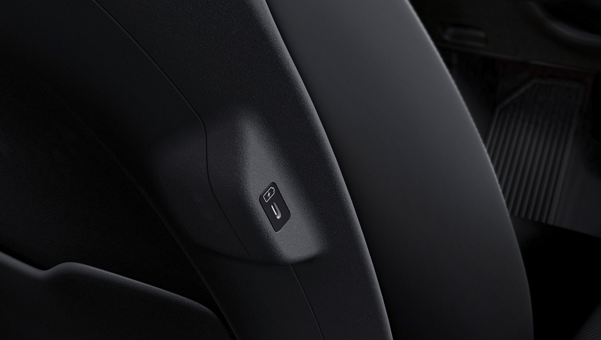 Puerto USB-C con icono de carga en el lateral de un asiento delantero del EV6