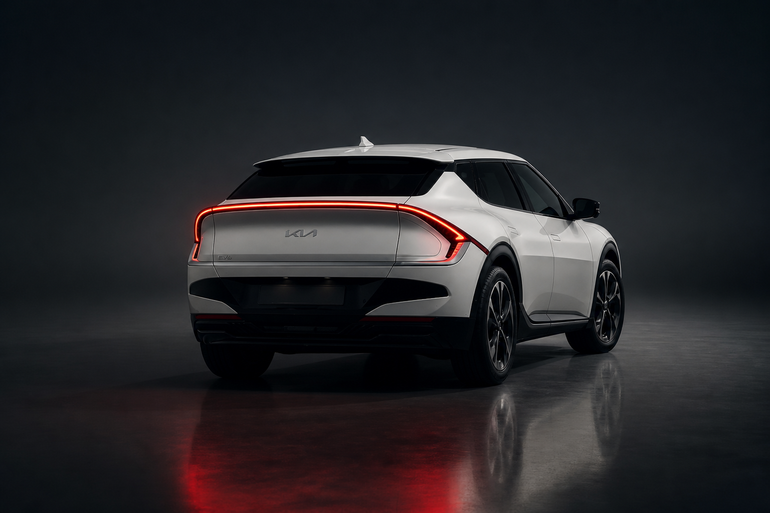 Kia EV6 blanco visto de espaldas en un plató oscuro, con la firma lumínica trasera Star Map protagonista