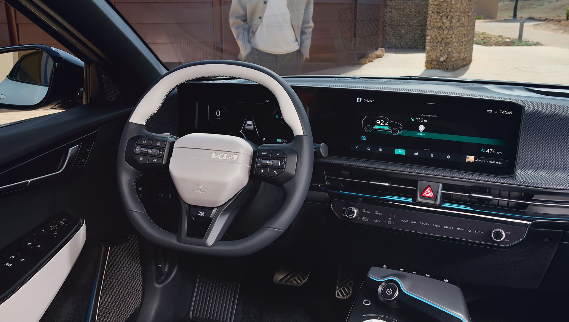 Manos del conductor sobre el volante del EV6, con las pantallas digitales al fondo