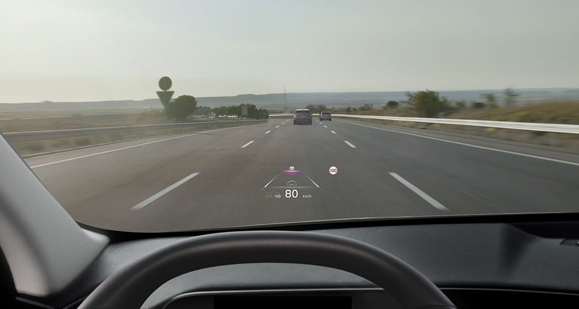 Vista desde el interior con el head-up display proyectado en el parabrisas mostrando velocidad y asistencia de carril