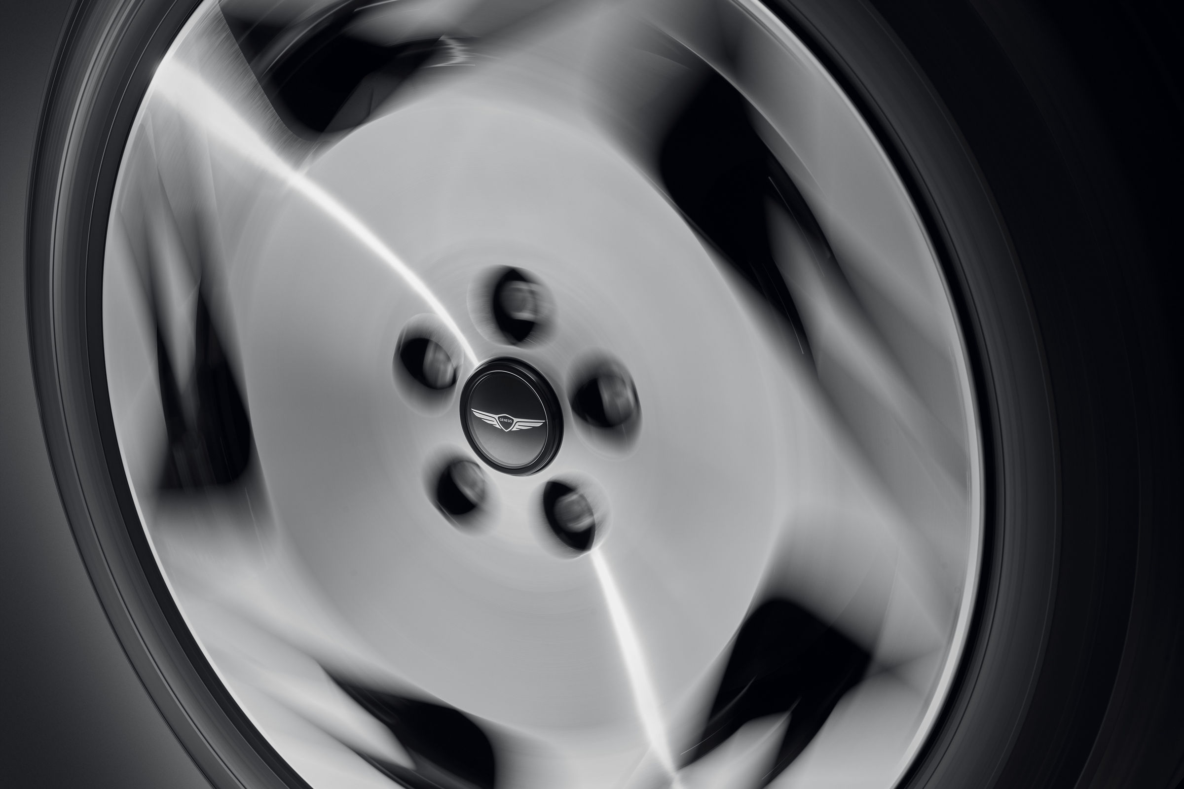 Detalle de la rueda con diseño aerodinámico y el logotipo de Genesis en el tapacubos